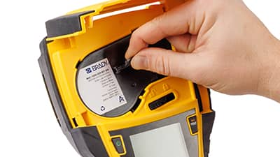 Eine Rolle mit Etikettenmaterialien wird in einen M710 Drucker eingelegt.