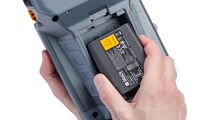 Eine Person legt einen hochleistungsfähigen Akku in einen Brady M510 Drucker ein