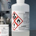 Ein Behälter mit Ethanol, der mit einem GHS-Sicherheitsetikett gekennzeichnet ist, auf dem der Inhalt angegeben ist.