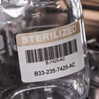 Ein Glasbehälter mit einem Barcode-Etikett, das die Sterilisation angezeigt.