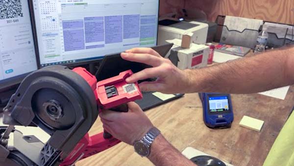 Eine Person zeigt auf ein Etikett auf einem Werkzeug.